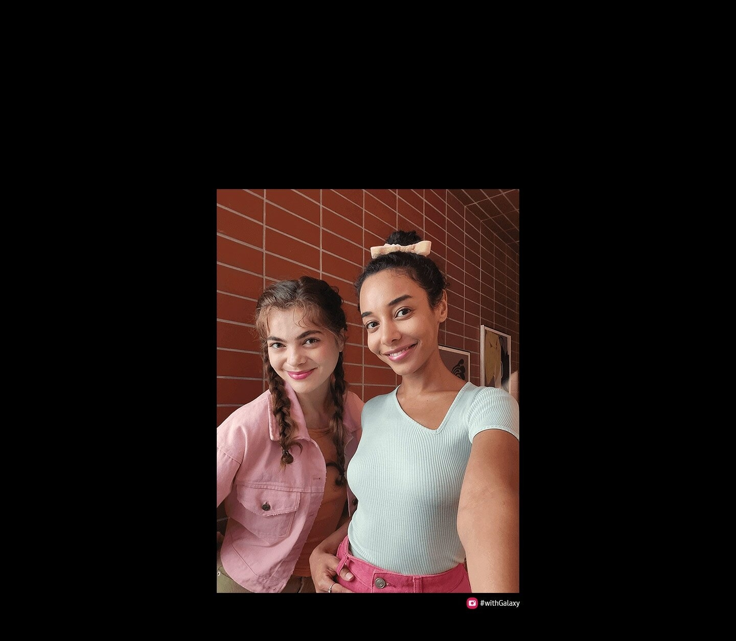 Deux femmes prennent un selfie avec le Galaxy S23 FE. La photo prise avec sa caméra frontale est aux couleurs vives…