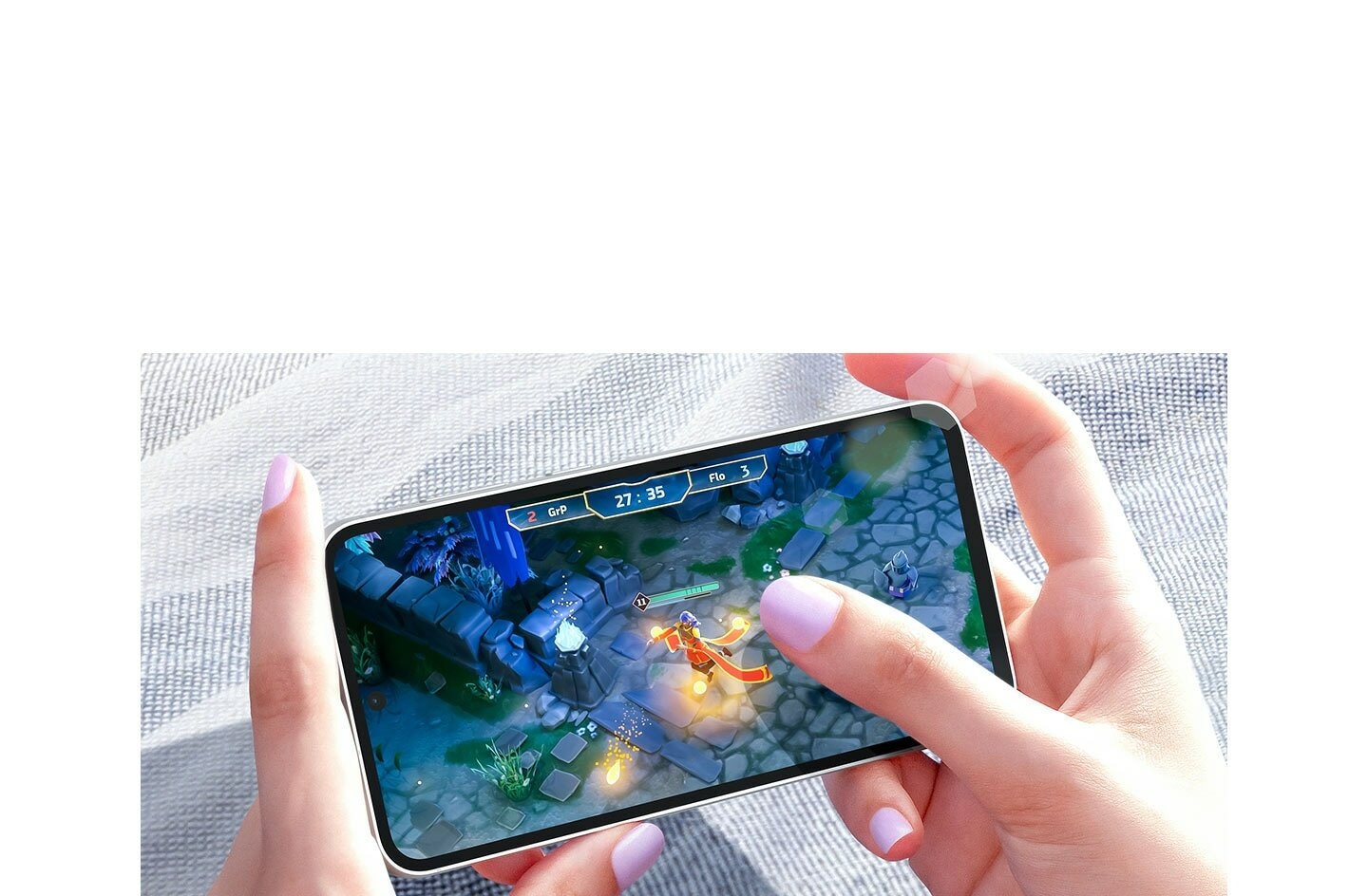 Deux mains jouant à un jeu vidéo sur un appareil Galaxy S23 FE en plein jour. L'écran affiche un…