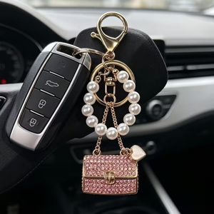 Porte-clés élégant, orné de strass et agrémenté d'un petit pendentif en forme de cœur .