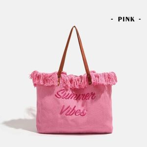 Sac à main en paille, idéal pour la plage, avec un design estival élégant de couleur rose.